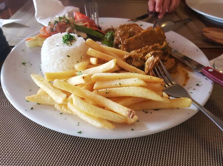 Foto de uma das refeições deliciosas de Aruba: essa se chama galinha stoba, tem arroz, batata frita e uma galinha temperada de forma diferente que não sei descrever, só provando pra saber